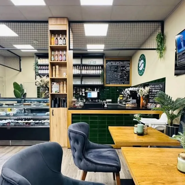 Innenraum von Café Tori mit Theke, Holzregalen, Tafel und Sitzplätzen